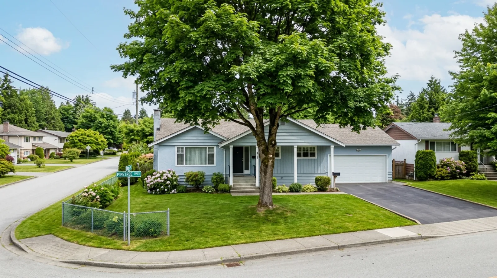 A 1960s post-war bungalow on a wide Mary Hill street in Port Coquitlam with a generous front lawn and a large driveway